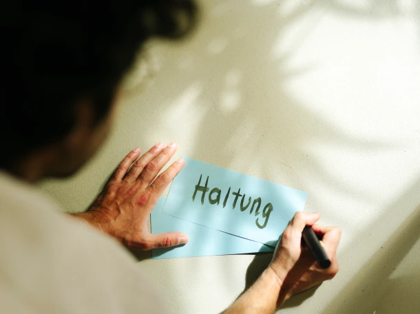 Ein Post-it in hellblau mit dem Wort Haltung